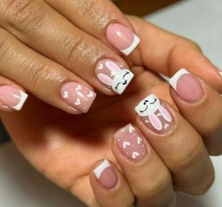 Pink and white French tip nails with cute sleeping bunny faces and hearts